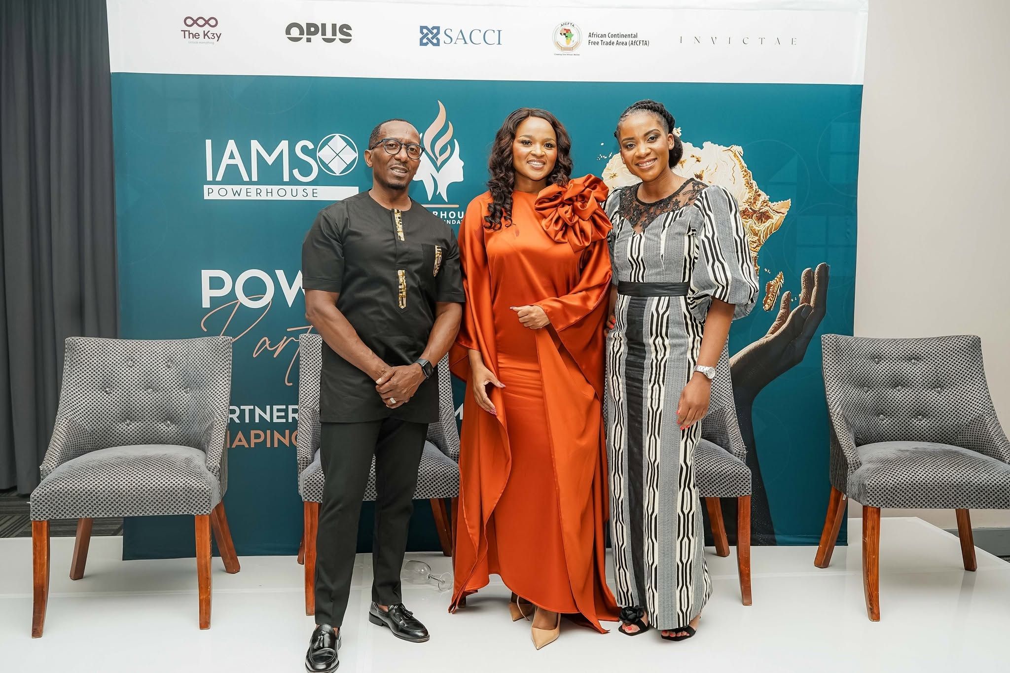 Three guests standing together in front of a partnership event backdrop